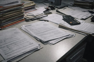 Στοίβες φακέλων και εγγράφων σε γραφείο δημόσιας υπηρεσίας στη Γερμανία, σύμβολο γραφειοκρατίας για το Bürgergeld.