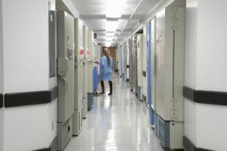 Διάδρομος δημόσιου νοσοκομείου στην Ελλάδα με ιατρικό προσωπικό στο βάθος.