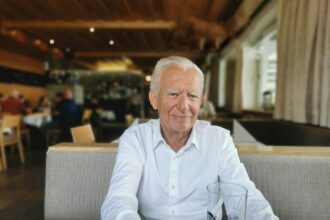 Ηλικιωμένο άτομο που εξετάζει έγγραφα για τη σύνταξή του στη Γερμανία.