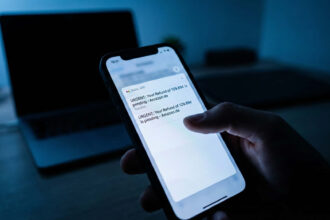 Κινητό τηλέφωνο που εμφανίζει ύποπτο email με λογότυπο Amazon και μήνυμα επιστροφής χρημάτων σε σκοτεινό φόντο