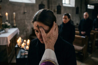 Καθολικός ιερέας σχηματίζει σταυρό με στάχτη στο μέτωπο πιστού κατά τη διάρκεια λειτουργίας