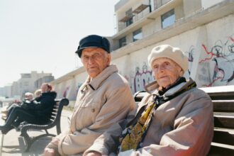 Ηλικιωμένοι πολίτες περπατούν σε εμπορικό δρόμο γερμανικής πόλης με θολωμένη κίνηση στο βάθος