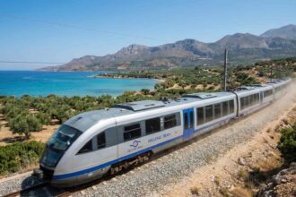 ύγχρονη αμαξοστοιχία εν κινήσει στο ελληνικό σιδηροδρομικό δίκτυο με φόντο ψηφιακά γραφικά χαρτογράφησης