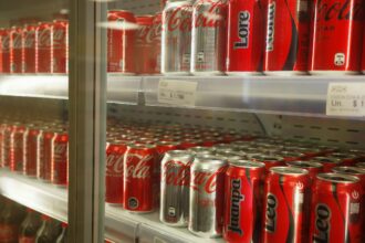 Διάδρομος σούπερ μάρκετ στη Γερμανία γεμάτος με μπουκάλια ζαχαρούχων αναψυκτικών και πελάτες που ψωνίζουν