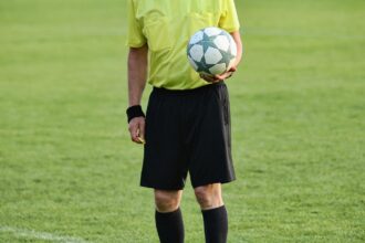 Άποψη του γηπέδου της Κολωνίας με θολωμένη φιγούρα διαιτητή στο προσκήνιο.