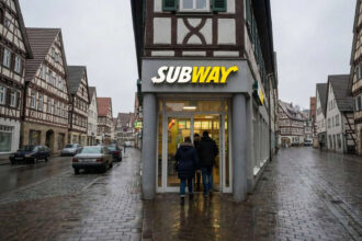 Εξωτερική άποψη καταστήματος Subway στη Γερμανία με πελάτες και πινακίδα λειτουργίας
