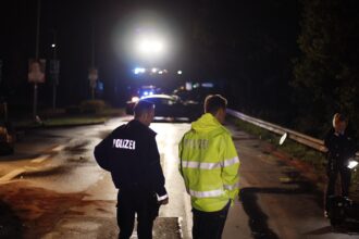Περιπολικό της γερμανικής αστυνομίας σε αυτοκινητόδρομο τη νύχτα με αναμμένους φάρους
