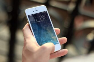 Άτομο κρατά smartphone με την εφαρμογή Ortelium με φόντο τον καθεδρικό ναό της Ουλμ