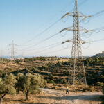 Stromleitungen und Energieinfrastruktur vor einem strahlend blauen Himmel in Griechenland