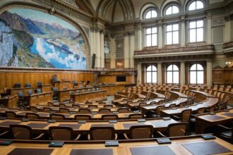 Αίθουσα συνεδριάσεων ελβετικού κοινοβουλίου με ξύλινα έδρανα και ψηφοφόρους