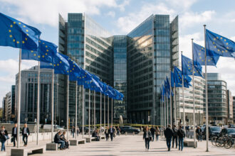 Ein offizielles Gebäude der Europäischen Union in Brüssel mit wehenden Europaflaggen im Vordergrund