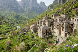 Eine kleine, orthodoxe Steinkirche in einem griechischen Bergdorf an einem sonnigen Frühlingstag.
