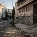 Ein Blick auf die Dächer von Athen mit einer Mischung aus modernen Gebäuden und verfallenen Strukturen.