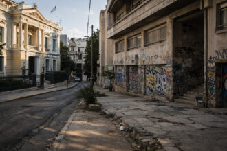 Ein Blick auf die Dächer von Athen mit einer Mischung aus modernen Gebäuden und verfallenen Strukturen.
