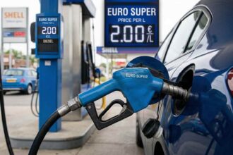 Αυτοκίνητο ανεφοδιάζεται με καύσιμα σε γερμανικό πρατήριο υγρών καυσίμων ενώ φαίνεται η ψηφιακή οθόνη τιμών