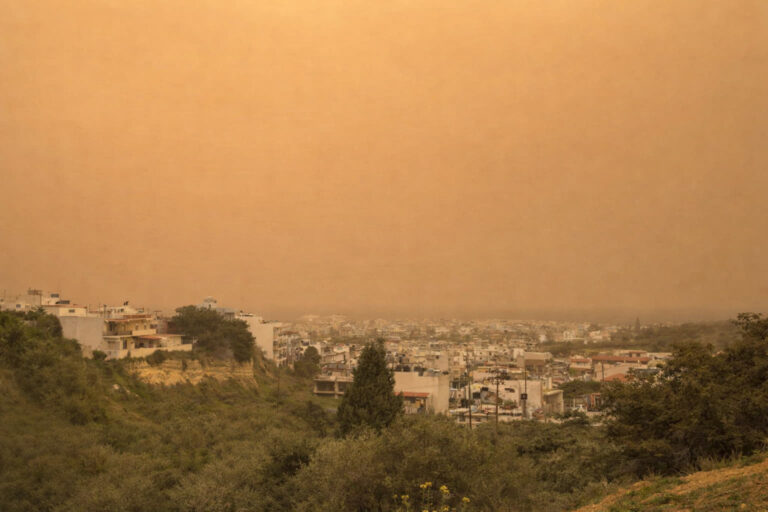Panoramablick auf eine Stadt auf Kreta unter Saharastaub und gelbem Himmel