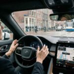 Ένα σύγχρονο ηλεκτρικό όχημα εν κινήσει σε αστικό δρόμο με τον οδηγό να παρακολουθεί το ταμπλό