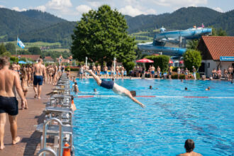Κόσμος απολαμβάνει το μπάνιο του σε ένα υπαίθριο ανοιχτό κολυμβητήριο στη Βαυαρία κάτω από τον ήλιο