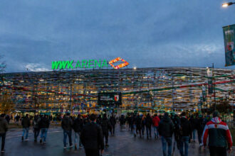 Eine Ansicht auf das moderne Fußballstadion in Augsburg am frühen Abend vor einem großen Spiel.