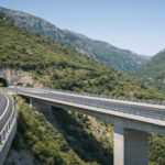 Moderne Autobahnbrücke und Tunnelportal der E65 in einer bergigen Landschaft in Griechenland