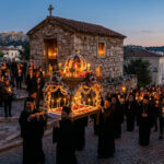Orthodoxe Gläubige mit brennenden Kerzen folgen dem blumengeschmückten Epitaph während der Karfreitagsprozession in einem griechischen Dorf bei Nacht