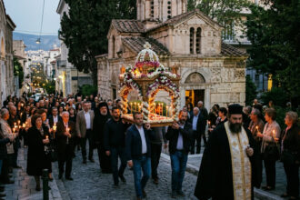 Gläubige folgen der Epitaph-Prozession vor einer kleinen, steinernen Kapelle in Athen bei Abenddämmerung
