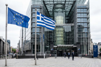Fahnen der Europäischen Union und Griechenlands wehen vor einem offiziellen Gerichtsgebäude in Brüssel
