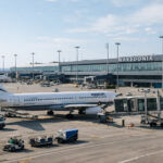 Mehrere Passagierflugzeuge parken auf dem Vorfeld des Flughafens Makedonia in Thessaloniki, im Hintergrund das Terminalgebäude.