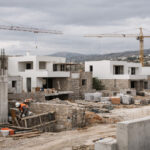 Eine Baustelle in Griechenland vor dem Hintergrund von Kränen und neuen Wohngebäuden.