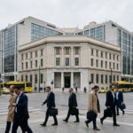 Moderne Architektur im Finanzviertel von Athen unter einem leicht bewölkten Himmel, passend zu den neuen Wirtschaftsprognosen.