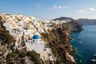 Πανοραμική άποψη παραδοσιακού χωριού σε βράχο πάνω από το γαλάζιο του Αιγαίου στην Κάρπαθο