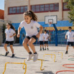 Kinder bei sportlichen Aktivitäten auf einem modernen Schulhof in Griechenland zur Förderung der Gesundheit