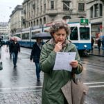 Άνθρωποι περπατούν προβληματισμένοι σε κεντρικό δρόμο ελβετικής πόλης