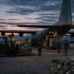 Ein militärisches Transportflugzeug auf einem Rollfeld bei Dämmerung in Vorbereitung auf Logistikflüge