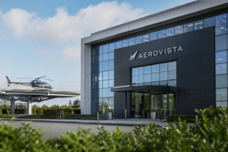 Zivile und militärische Hubschrauber auf einem Flugfeld vor einem modernen Bürogebäude.