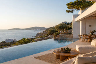 Eine moderne Luxusvilla mit Pool an der griechischen Küste bei Sonnenuntergang.