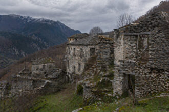 Verlassene Steinruinen in einer bergigen Landschaft in Nordgriechenland unter bewölktem Himmel