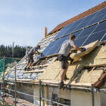 Εργάτες τοποθετούν ηλιακά πάνελ στη στέγη μιας ανακαινισμένης κατοικίας στη Γερμανία