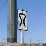 Ein Verkehrsschild und eine Verkehrsampel an einer viel befahrenen Straße in Athen