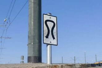 Ein Verkehrsschild und eine Verkehrsampel an einer viel befahrenen Straße in Athen