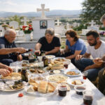 Eine griechische Familie sitzt am Ostermontag auf einem Friedhof in Kozani um ein Grab und teilt ein Festmahl.
