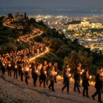 Eine friedliche Kerzenprozession in der Nacht mit Blick auf das beleuchtete Athen