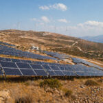 Großer Solarpark in Griechenland vor einer Berglandschaft an einem sonnigen Tag