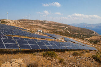 Großer Solarpark in Griechenland vor einer Berglandschaft an einem sonnigen Tag