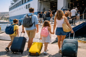 Griechische Familie mit Gepäck geht an Bord einer Fähre im Hafen