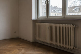Καλοριφέρ σε διαμέρισμα στη Γερμανία με φόντο λογαριασμούς