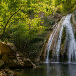 Ein Blick auf die dichte grüne Vegetation und einen kleinen Wasserfall in der Region Potami auf der Insel Samos.