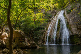 Ein Blick auf die dichte grüne Vegetation und einen kleinen Wasserfall in der Region Potami auf der Insel Samos.