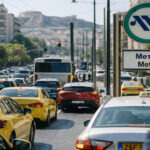Starker Autoverkehr in Athen mit einem sichtbaren Metro-Schild im Hintergrund.