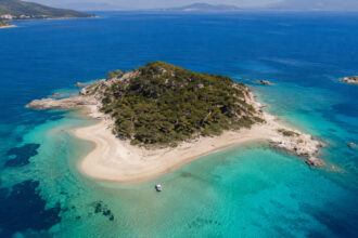 Türkisblaues flaches Wasser und feiner Sandstrand auf der unbewohnten Hauptinsel Monolia der Lichadonisia-Gruppe in Griechenland.